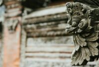 Close-up of an intricate stone carving on a traditional Balinese temple wall, showcasing cultural artistry.