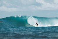 Surfer riding a massive ocean wave in Bali, capturing the thrill and beauty of water sports.