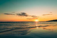 Captivating sunset over the Adriatic Sea with clear skies and a tranquil beach ambiance in Montenegro.