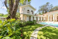 Charming villa surrounded by lush garden and pool, ideal for luxury living.