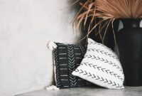 Stylish minimalist decor featuring a black ceramic vase and patterned throw pillows in a Bali interior.