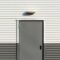 Minimalist image of a corrugated metal wall with a centered door, showcasing industrial architecture.