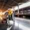 A traveler's baggage cart on an urban railway station platform at sunrise.