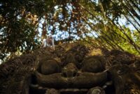Komaneka At Tanggayuda Luxury Jungle Retreat In Ubud Bali A monkey sitting on an ornate sculpture in Ubud's lush monkey forest.