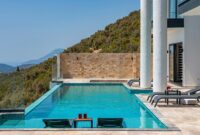 Mandalay Villas Exclusive Villas With Stunning Hilltop Views Infinity pool with mountain view and sun loungers in a sunny villa setting.