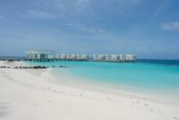 Luxurious overwater villas on a pristine beach with turquoise waters and clear blue skies.