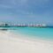 Luxurious overwater villas on a pristine beach with turquoise waters and clear blue skies.