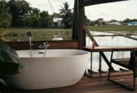 Theanna Eco Villa And Spa Luxury Eco Retreat In Seminyak Bali Relaxing outdoor bathtub on wooden deck overlooking a serene rural landscape.